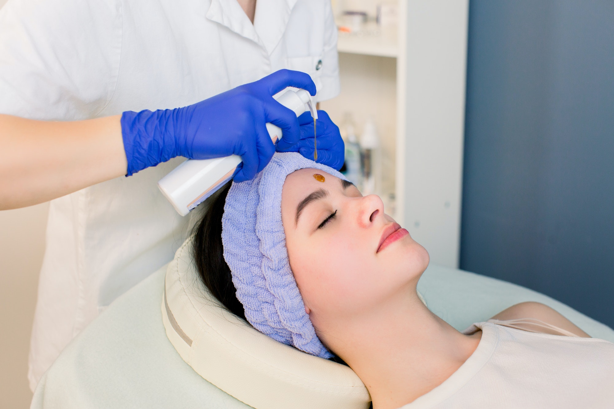 Beautiful Face Skin. Cosmetologist doing beauty procedure for patient. Face massage, skincare. Woman