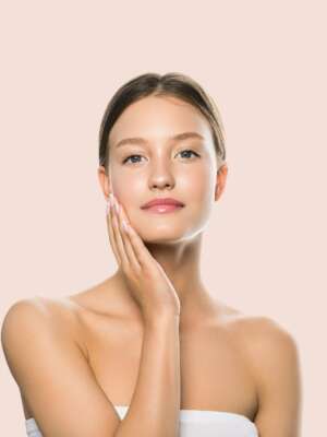 Beauty skin woman hand touching face healthy natural make up clean fresh skin Color background pink